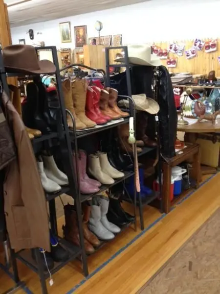 A store interior displays shelves of cowboy boots and hats.