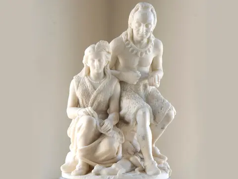 A white marble sculpture depicting a man and a woman.
