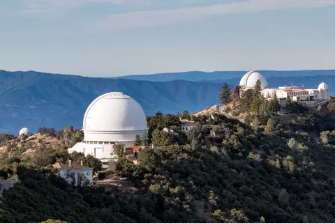 An observatory with large domes perched on a mountain ridge.