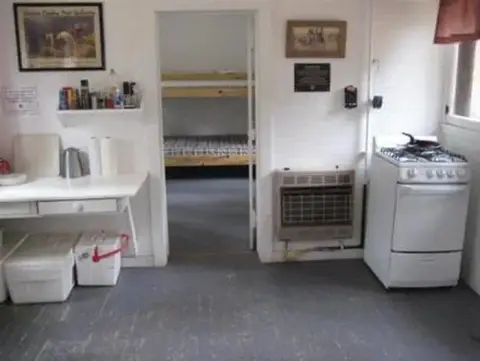 An interior view of a room with a kitchen area and a doorway leading to a bunk room.