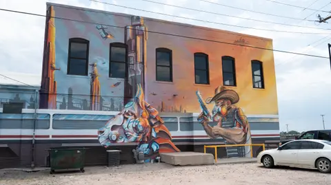 A large sci-fi mural painted on the exterior brick wall of a building.