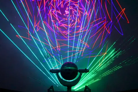 A planetarium projector displays colorful laser light patterns.