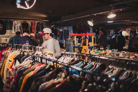 People browse through racks of clothing inside a vintage shop.