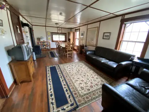An interior view of a living room with a couch, television, and dining area.
