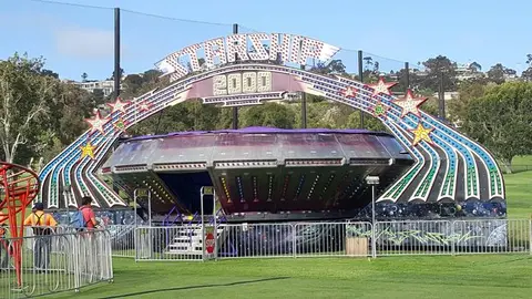 An amusement park ride set up on a grassy field.