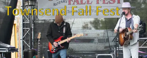 A band performs on a stage during an outdoor festival.