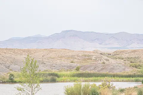 A body of water in front of arid hills and mountains.