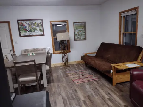 An interior view of a room with a dining table and a brown futon.