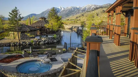 An outdoor view of a resort with a hot tub and mountain backdrop.
