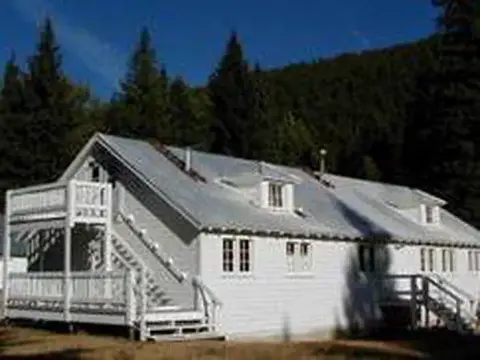 An exterior view of a white building with a metal roof and an outdoor staircase.