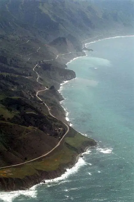 Aerial view of a winding coastal highway alongside the ocean.
