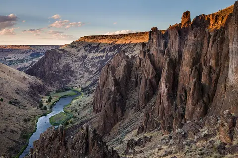 A winding river flowing through a deep canyon with rocky cliffs.