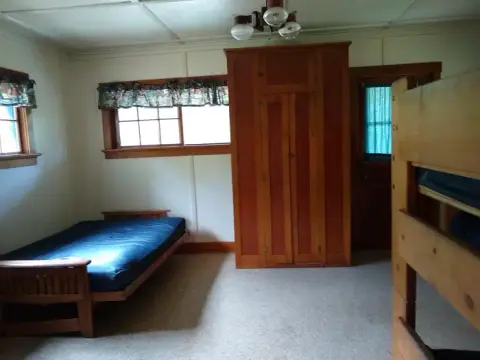 An interior view of a bedroom with wooden furniture and a bed.