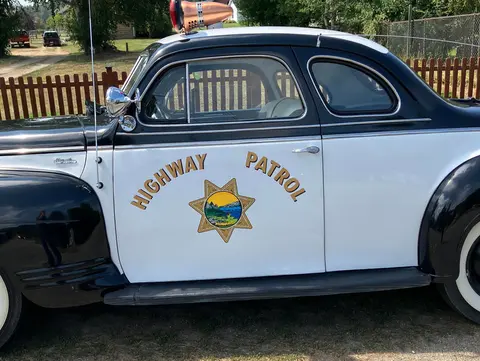 A vintage highway patrol car parked outdoors.
