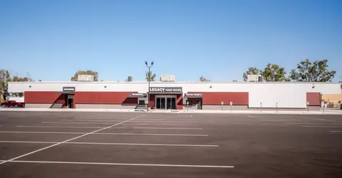 A single-story building with a large parking lot in front.