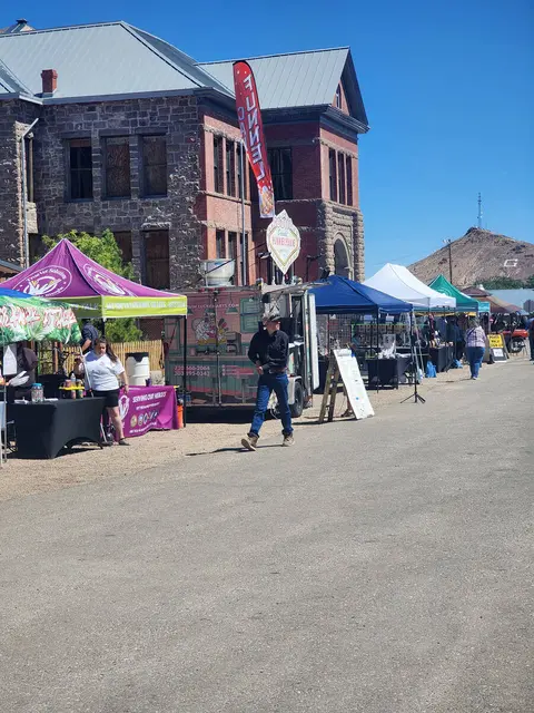 A street market or festival in front of an old stone building.