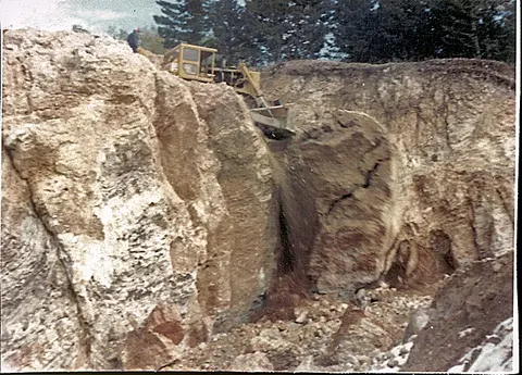 A bulldozer working in a rocky excavation site.