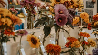 A display of various colorful flowers in vases.