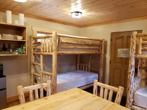 An interior shot of a rustic room with log bunk beds.