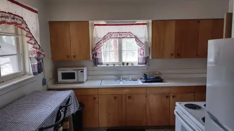 An interior view of a kitchen with wooden cabinets and a sink.
