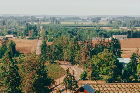 An elevated view shows a rural landscape with roads, fields, and trees.
