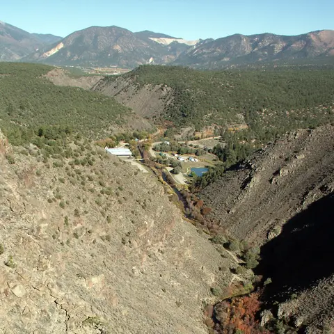 A view of a mountain valley with steep slopes and distant peaks.