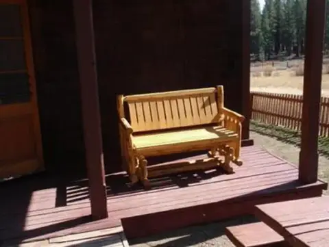 A wooden bench sits on the porch of a building.