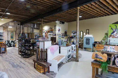 An interior view of a store displaying various home goods, furniture, and art.