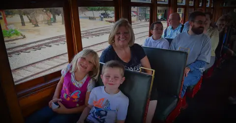 People riding inside a vintage train car.