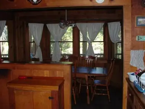 A rustic wooden dining area viewed from an adjacent room.