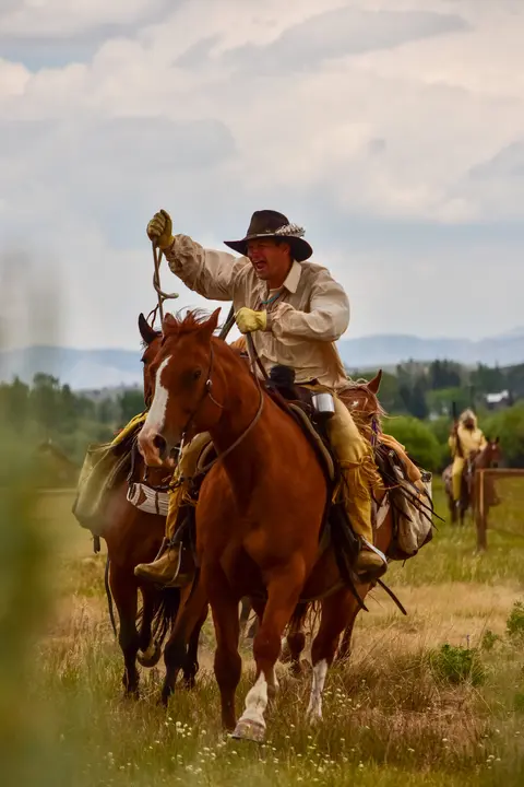 A man riding a horse across an open field.