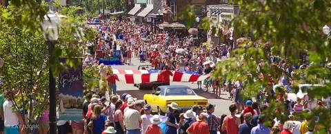 A large crowd gathers along a street for a parade.