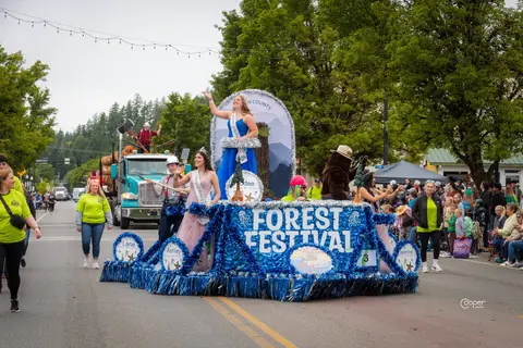 A parade float with people waving to a crowd.
