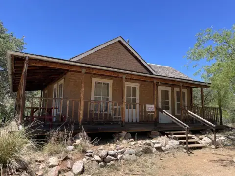 A rustic building with a wooden porch under a clear blue sky.