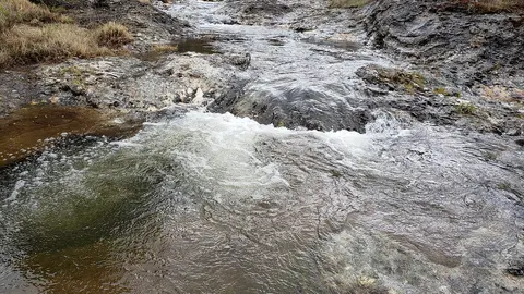 A small stream flowing over rocky terrain.