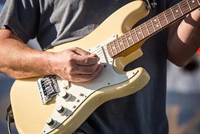 A person playing an electric guitar.