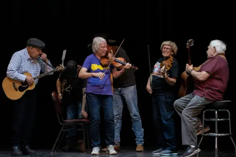 A group of musicians playing instruments on a stage.