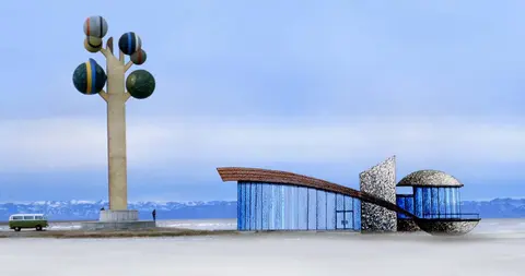 A rendering of an artistic sculpture and a modern building in an open landscape.