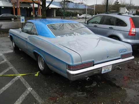 A custom blue and silver classic Chevrolet car is parked in an outdoor parking lot.