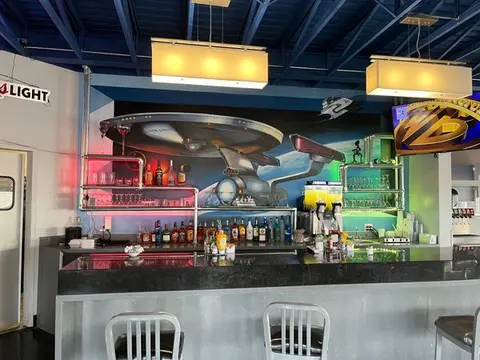 An interior view of a bar featuring a Star Trek mural on the back wall.