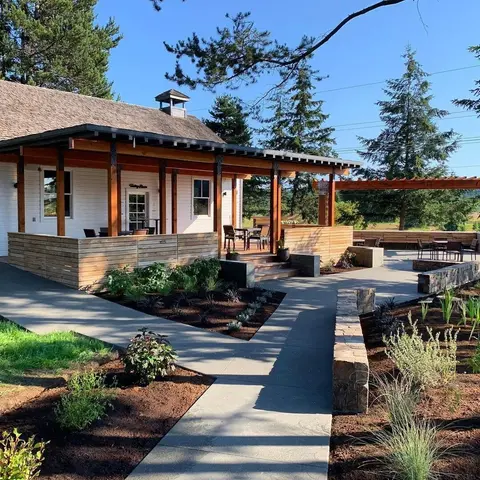 A single-story building with a wooden porch and outdoor seating area.