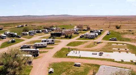 An aerial view of an RV park in a flat, arid landscape.