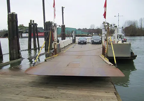 A car ferry docked at a pier.