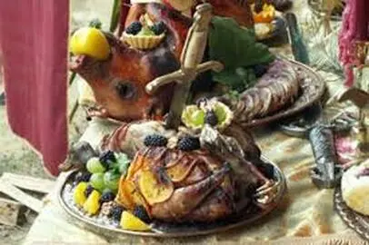 A medieval feast with roasted meats and fruit.