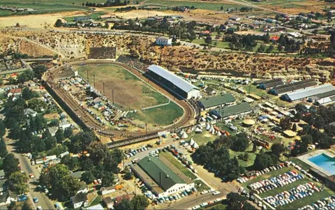 An aerial view of a race track and surrounding fairgrounds.