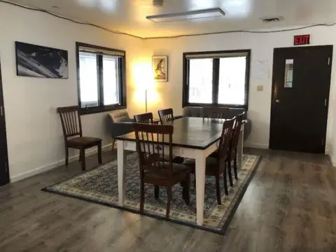 An interior view of a room with a dining table and chairs.