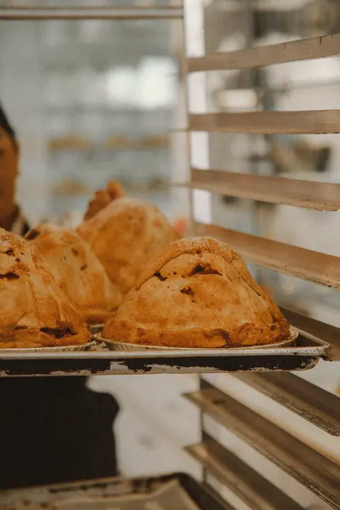 A tray of freshly baked pies in a kitchen.