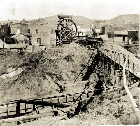 Historic photograph of mining operations near a town.