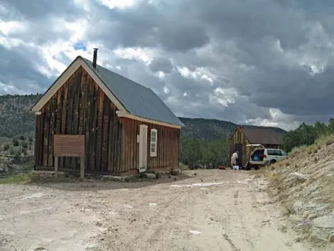 A rustic wooden building under a cloudy sky.