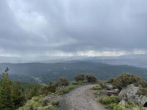 A scenic view of a mountainous landscape under a cloudy sky.